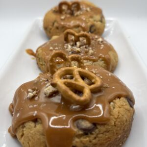 Cookies topped with caramel sauce and pretzels.